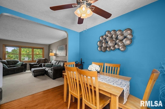 2401 W Dale Ct, Bettendorf, IA 52722 - dining room with a textured ceiling, wood finished floors, ceiling fan, and arched walkways