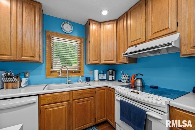 2401 W Dale Ct, Bettendorf, IA 52722 - kitchen featuring white appliances, under cabinet range hood, light countertops, and brown cabinets