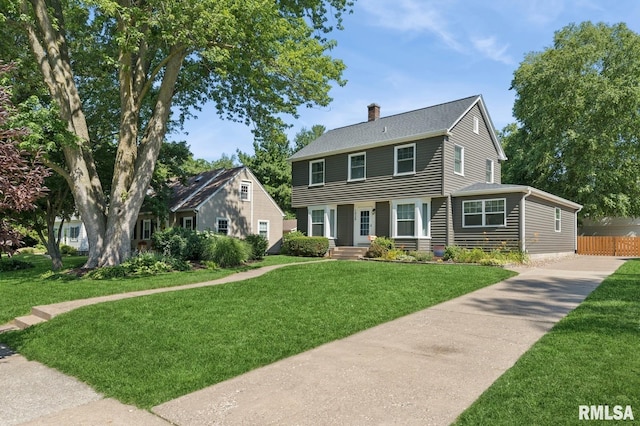 1928 Elm St, Davenport, IA 52803 - colonial house featuring a chimney, a shingled roof, and driveway