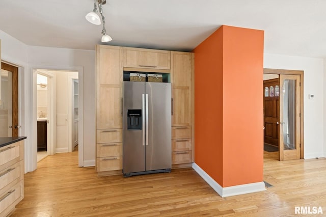 1928 Elm St, Davenport, IA 52803 - kitchen featuring stainless steel fridge, light brown cabinets, light wood-type flooring, and dark countertops