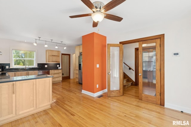 1928 Elm St, Davenport, IA 52803 - kitchen with stainless steel appliances, light brown cabinets, dark countertops, backsplash, and light wood-type flooring
