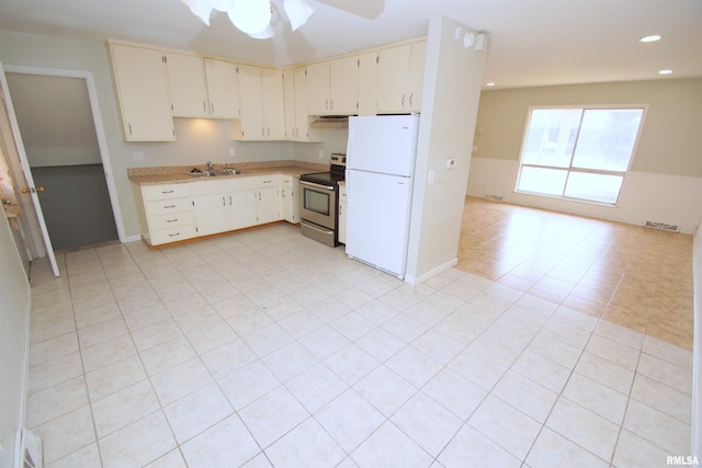 3618 18th St, Bettendorf, IA 52722 - kitchen with stainless steel electric range oven, freestanding refrigerator, light countertops, wainscoting, and ceiling fan