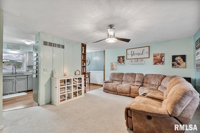 1215 Calvin St, Davenport, IA 52804 - living room featuring carpet floors, a textured ceiling, and a ceiling fan