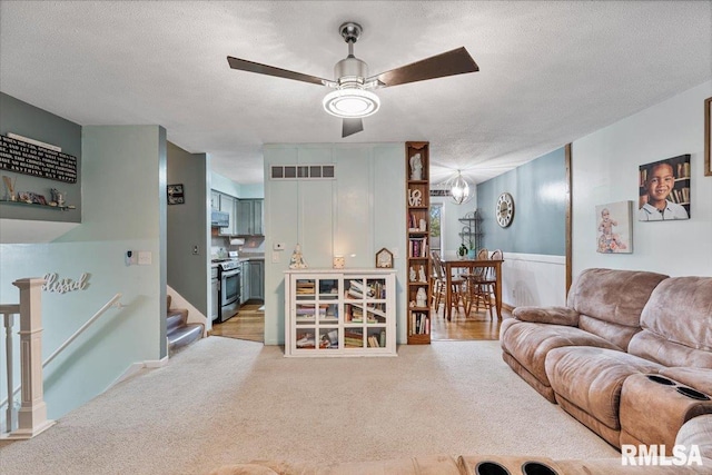 1215 Calvin St, Davenport, IA 52804 - living room with light carpet, ceiling fan, a textured ceiling, and stairway