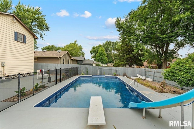 1215 Calvin St, Davenport, IA 52804 - view of swimming pool featuring a water slide, a diving board, and a fenced backyard