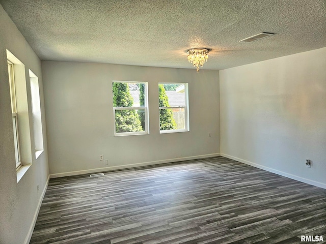 1912 Breese St, Muscatine, IA 52761 - spare room featuring dark wood-style flooring and a textured ceiling