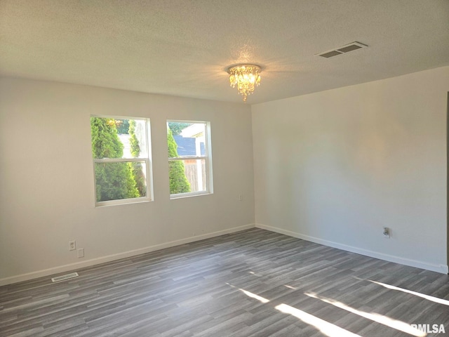 1912 Breese St, Muscatine, IA 52761 - unfurnished room with a chandelier, wood finished floors, and a textured ceiling
