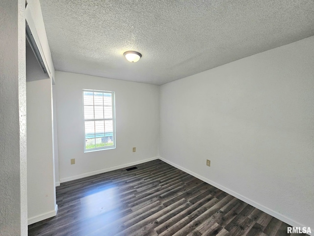 1912 Breese St, Muscatine, IA 52761 - spare room with dark wood-type flooring and a textured ceiling