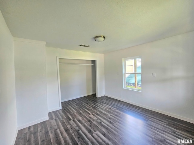 1912 Breese St, Muscatine, IA 52761 - unfurnished bedroom with dark wood-type flooring and a closet