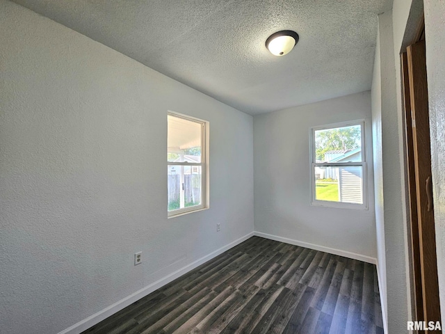 1912 Breese St, Muscatine, IA 52761 - empty room featuring dark wood finished floors, a textured ceiling, and a textured wall