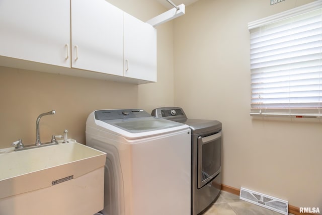 1199 Scenic Place, Le Claire, IA 52753 - laundry area featuring washer and clothes dryer, cabinet space, and light tile patterned floors