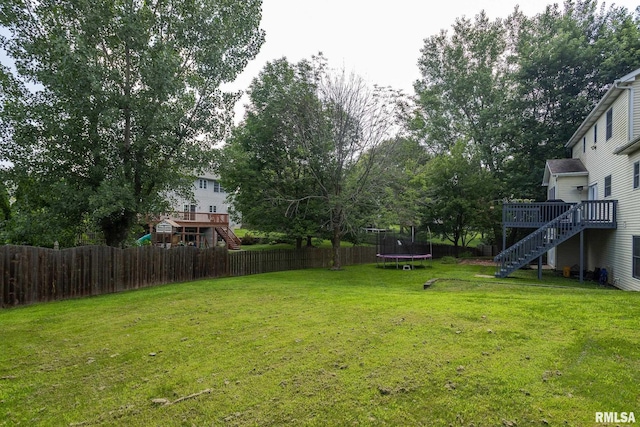 1199 Scenic Place, Le Claire, IA 52753 - fenced backyard with a trampoline, stairs, and a wooden deck