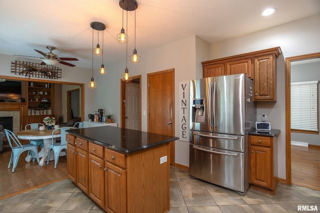 1199 Scenic Place, Le Claire, IA 52753 - kitchen featuring stainless steel refrigerator with ice dispenser, a ceiling fan, brown cabinets, a center island, and hanging light fixtures