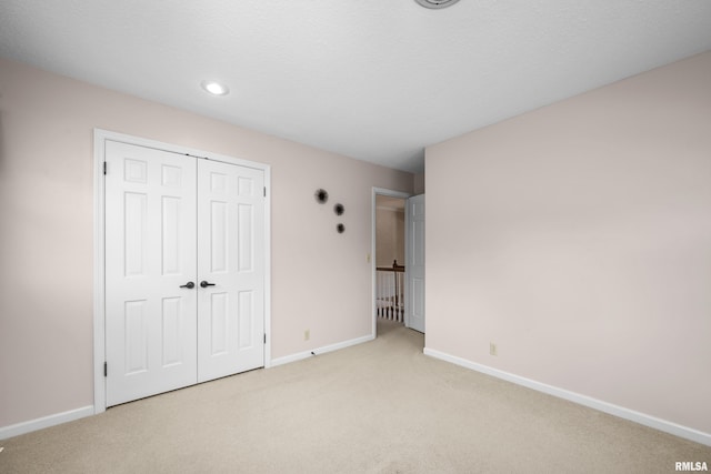 2303 Wynnewood Ct, Davenport, IA 52807 - unfurnished bedroom with light carpet, a closet, and recessed lighting