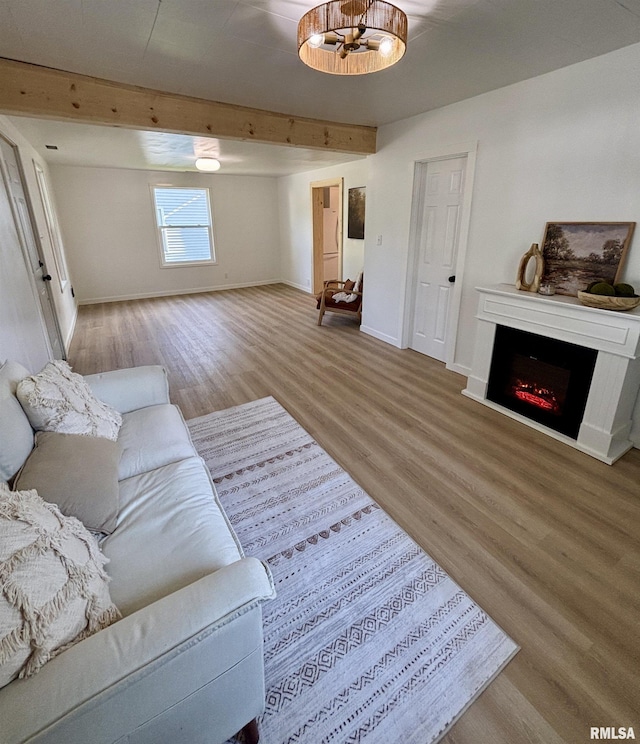 527 S Rotan St, Salem, IL 62881 - living room featuring wood finished floors, beam ceiling, and a lit fireplace