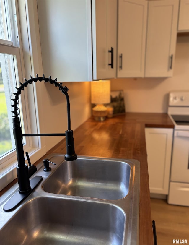 527 S Rotan St, Salem, IL 62881 - kitchen view of electric stove, white cabinets, and light wood-style flooring