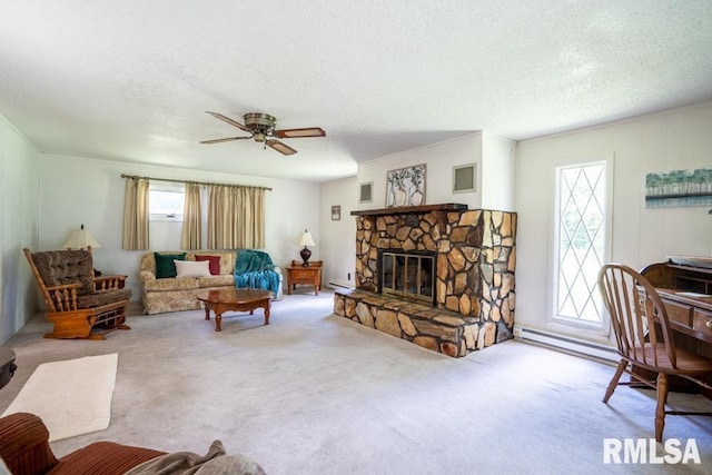 206 Patricia Ln, West Frankfort, IL 62896 - living room with a textured ceiling, carpet, a stone fireplace, ceiling fan, and a baseboard heating unit