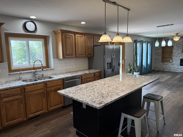 124 Riverview Heights Dr, Le Claire, IA 52753 - kitchen featuring stainless steel appliances, a kitchen bar, dark wood finished floors, light stone counters, and recessed lighting