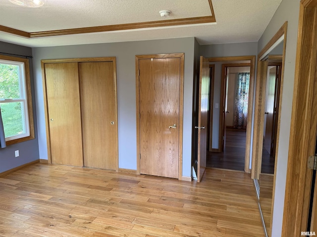 124 Riverview Heights Dr, Le Claire, IA 52753 - unfurnished bedroom featuring a textured ceiling, two closets, and light wood-type flooring