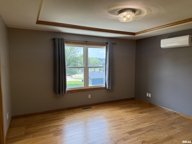 124 Riverview Heights Dr, Le Claire, IA 52753 - spare room featuring a textured ceiling, light wood-style floors, and an AC wall unit