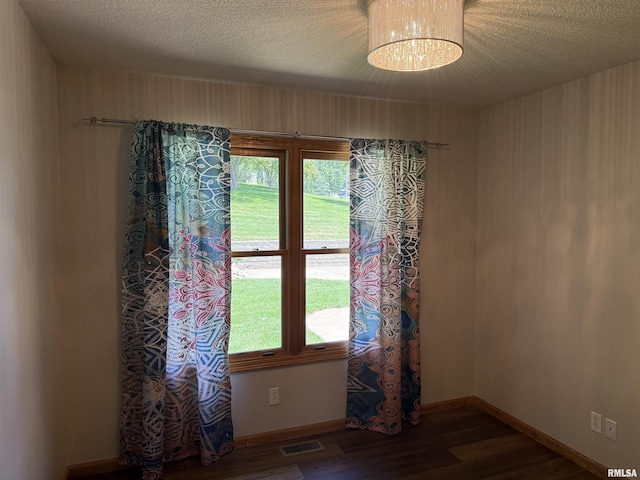 124 Riverview Heights Dr, Le Claire, IA 52753 - unfurnished room featuring wood finished floors, a textured ceiling, and a chandelier