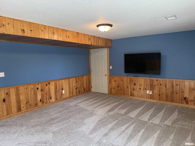 124 Riverview Heights Dr, Le Claire, IA 52753 - unfurnished living room with wainscoting, carpet flooring, a textured ceiling, and wooden walls