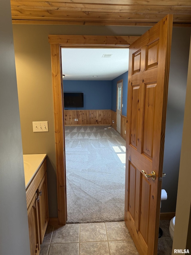 124 Riverview Heights Dr, Le Claire, IA 52753 - bathroom with vanity, wainscoting, wooden walls, and wood ceiling