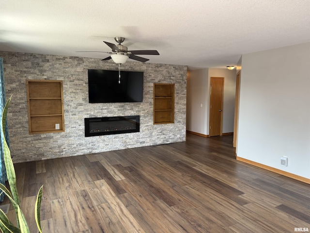 124 Riverview Heights Dr, Le Claire, IA 52753 - unfurnished living room with ceiling fan, a glass covered fireplace, wood finished floors, built in features, and a textured ceiling