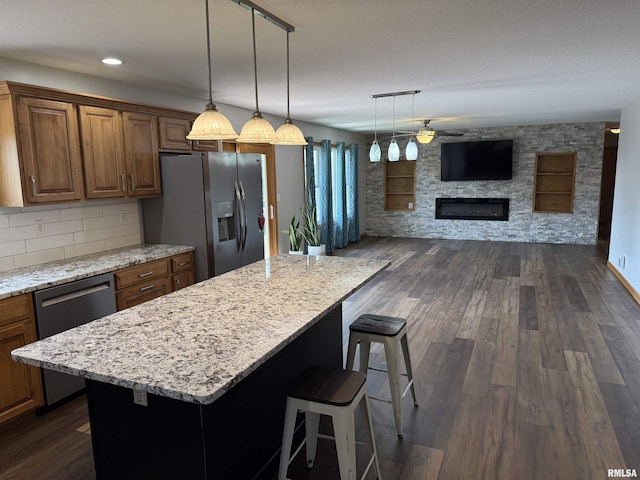 124 Riverview Heights Dr, Le Claire, IA 52753 - kitchen featuring appliances with stainless steel finishes, dark wood-style floors, light stone counters, and recessed lighting