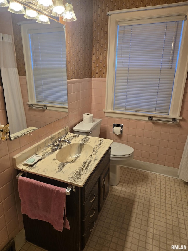 621 E 29th St, Davenport, IA 52803 - bathroom with wallpapered walls, wainscoting, tile walls, a chandelier, and vanity