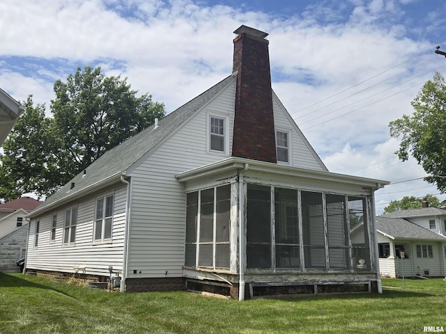 621 E 29th St, Davenport, IA 52803 - back of property featuring a sunroom, roof with shingles, a lawn, and a chimney