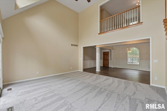 1 S Shore Ln, Rapids City, IL 61278 - unfurnished living room with carpet, ornate columns, high vaulted ceiling, ceiling fan, and wainscoting
