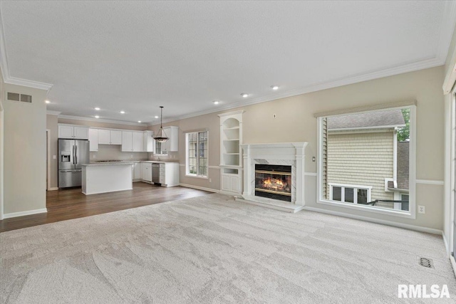 1 S Shore Ln, Rapids City, IL 61278 - unfurnished living room featuring dark colored carpet, ornamental molding, plenty of natural light, a fireplace, and recessed lighting