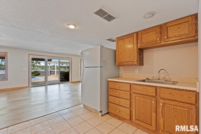 1 S Shore Ln, Rapids City, IL 61278 - kitchen featuring a textured ceiling, freestanding refrigerator, light countertops, open floor plan, and brown cabinets