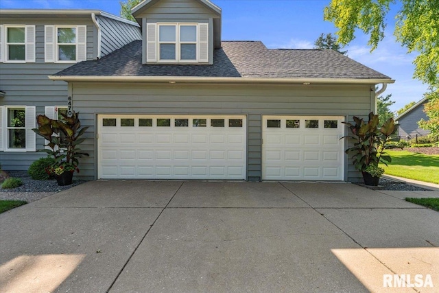 6470 James Rd, Bettendorf, IA 52722 - view of front facade featuring driveway, roof with shingles, and a garage