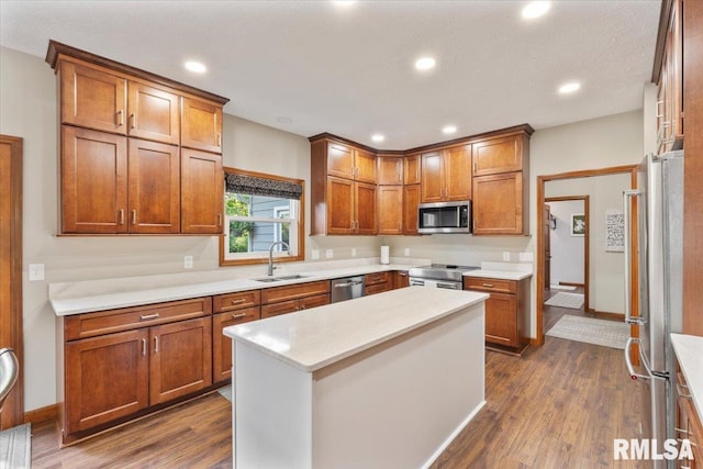 6470 James Rd, Bettendorf, IA 52722 - kitchen with dark wood-style floors, stainless steel appliances, light countertops, brown cabinets, and recessed lighting