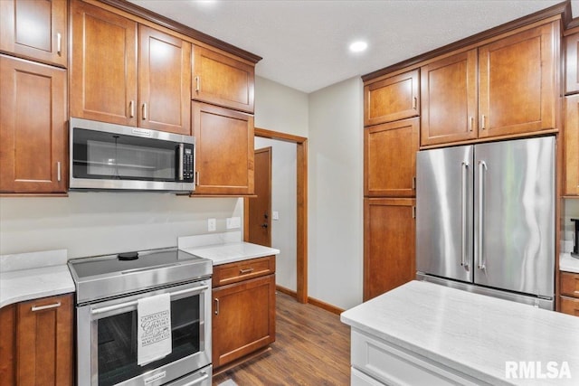 6470 James Rd, Bettendorf, IA 52722 - kitchen featuring stainless steel appliances, dark wood-type flooring, brown cabinetry, and recessed lighting