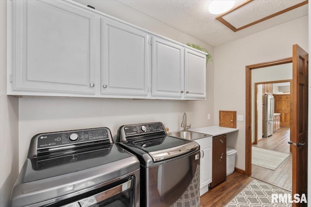 6470 James Rd, Bettendorf, IA 52722 - laundry room with cabinet space, independent washer and dryer, wood finished floors, and a textured ceiling