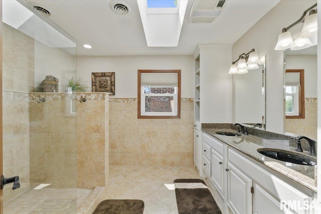6470 James Rd, Bettendorf, IA 52722 - full bathroom featuring tile walls, walk in shower, double vanity, tile patterned flooring, and wainscoting