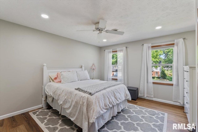 6470 James Rd, Bettendorf, IA 52722 - bedroom with wood finished floors, recessed lighting, ceiling fan, and a textured ceiling