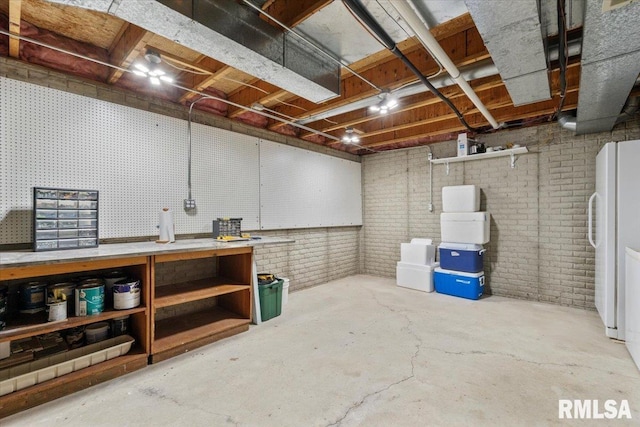 6470 James Rd, Bettendorf, IA 52722 - unfinished below grade area with a workshop area, freestanding refrigerator, and brick wall