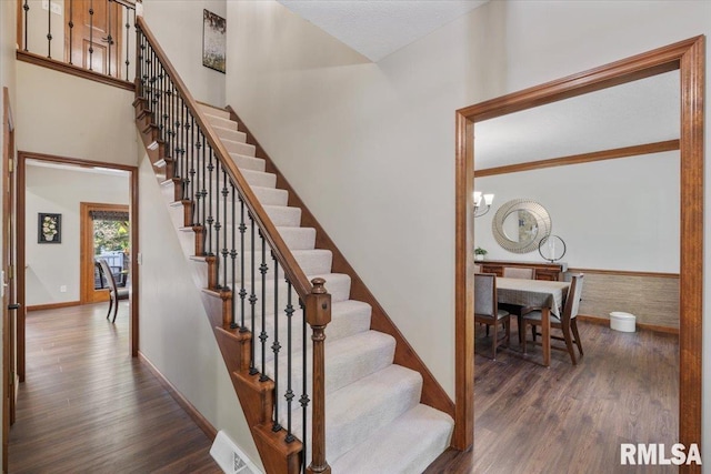 6470 James Rd, Bettendorf, IA 52722 - stairs featuring wood finished floors and a chandelier