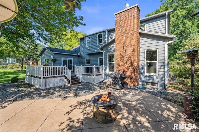 6470 James Rd, Bettendorf, IA 52722 - rear view of house with an outdoor fire pit, a wooden deck, a patio, and a chimney