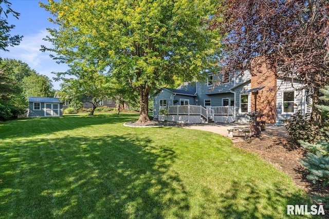 6470 James Rd, Bettendorf, IA 52722 - view of grassy yard featuring a wooden deck and a storage shed