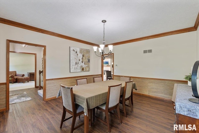 6470 James Rd, Bettendorf, IA 52722 - dining space with a wainscoted wall, a chandelier, dark wood-style flooring, and ornamental molding