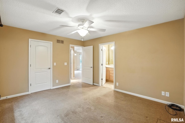 2997 3rd St Unit 206, Moline, IL 61265 - unfurnished bedroom featuring light colored carpet, ensuite bathroom, a textured ceiling, and ceiling fan