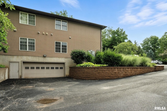 2997 3rd St Unit 206, Moline, IL 61265 - view of property exterior featuring an attached garage, driveway, and brick siding