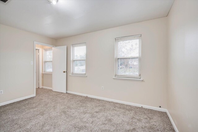 carpeted empty room featuring plenty of natural light