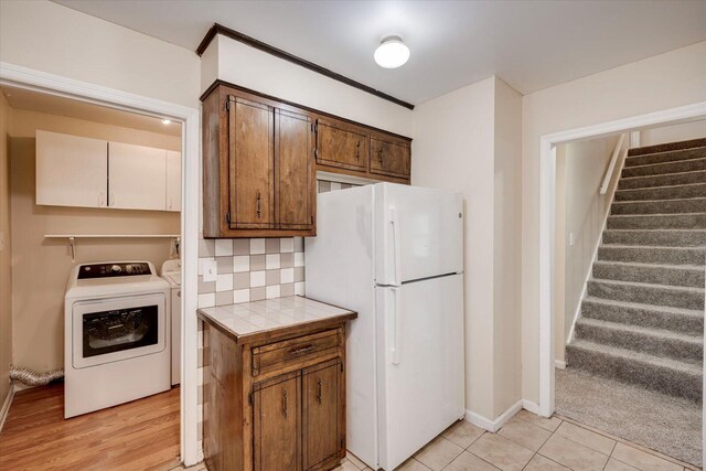 kitchen with backsplash, tile counters, white fridge, and light tile patterned floors