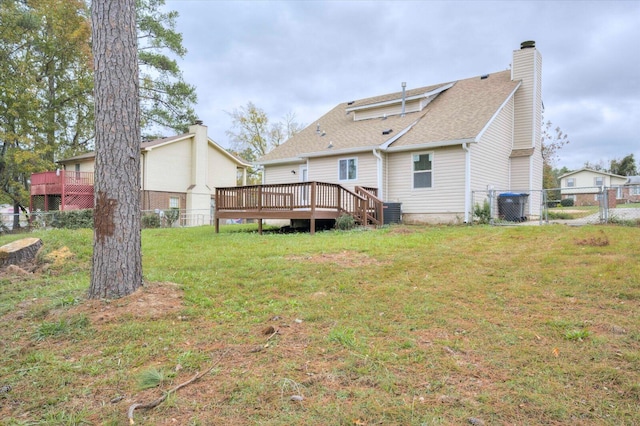 rear view of property with a lawn and a deck